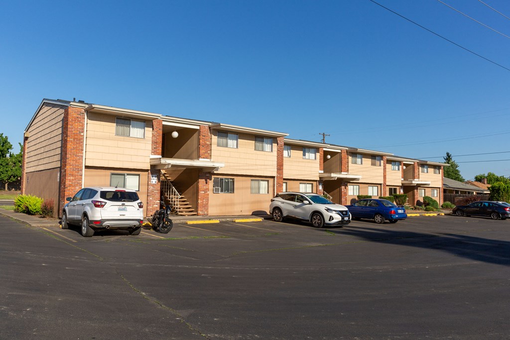 a large apartment building with cars parked in front of it