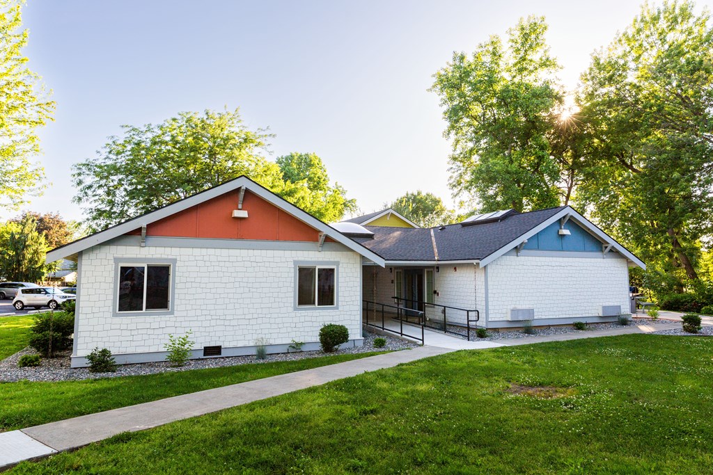 a white house with an orange and white roof and a sidewalk