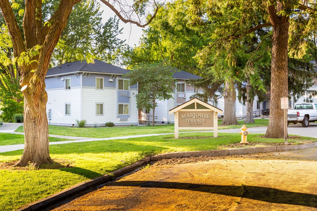 a white house with a sign and trees in front of it