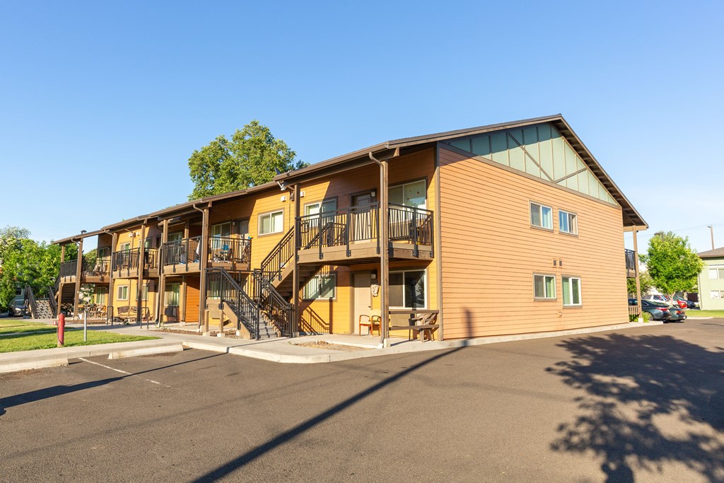 the exterior of a building with balconies and a parking lot