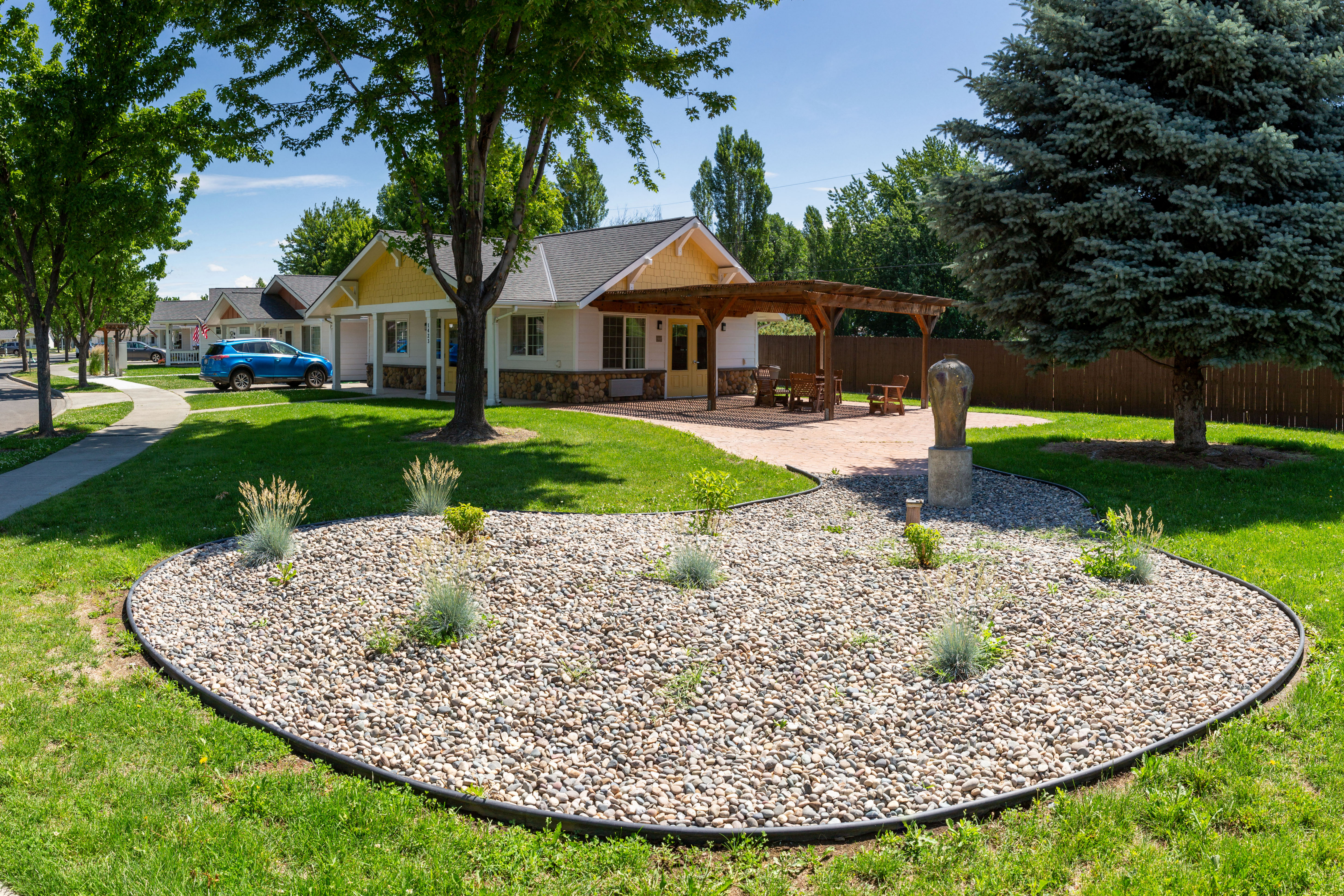 a round rock garden in front of a house