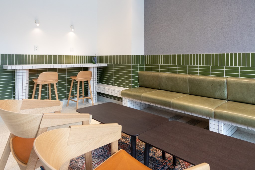 a seating area with tables and chairs and a bar