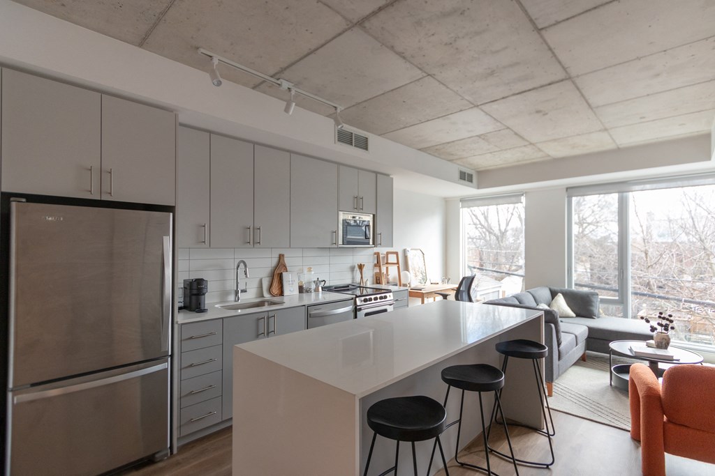 a kitchen and living room with a large island and stools