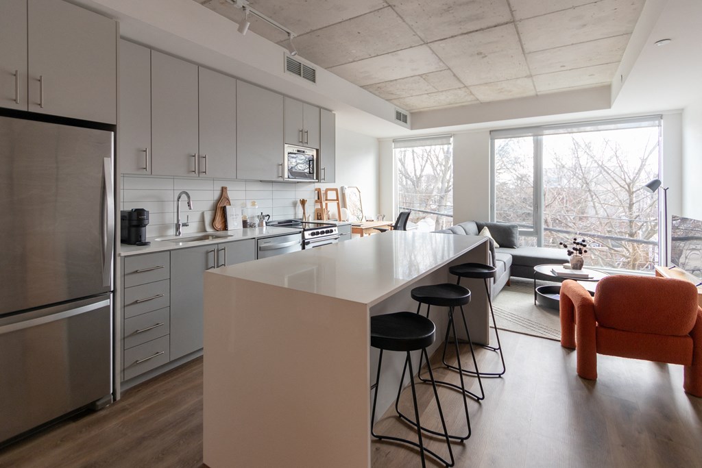 a kitchen and living room with an island and stools in a house