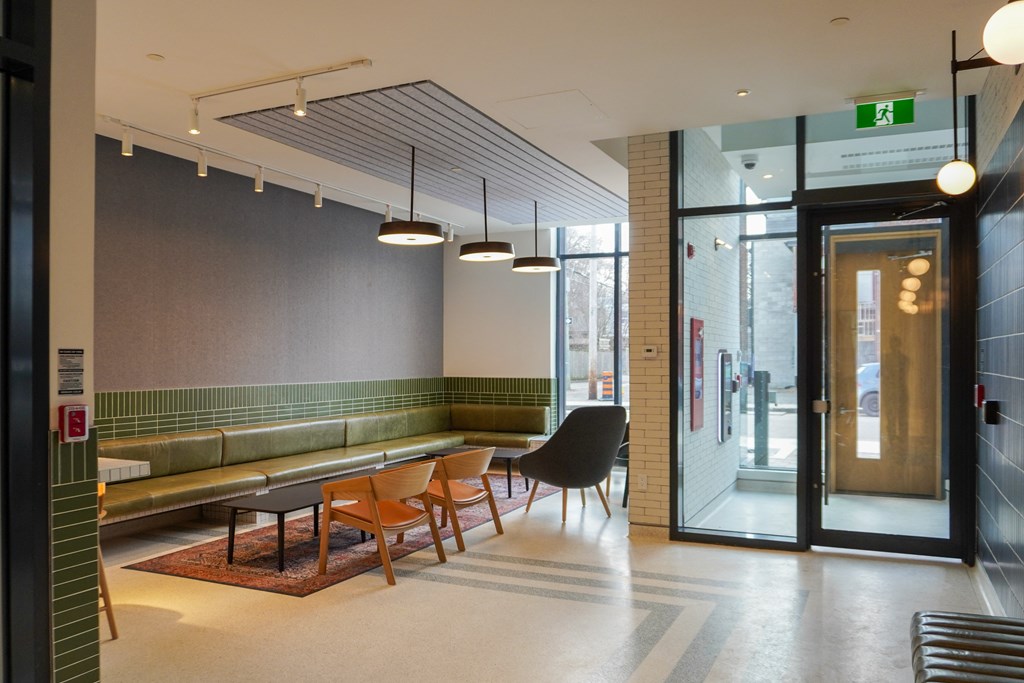 a lounge area with chairs and tables and a glass door