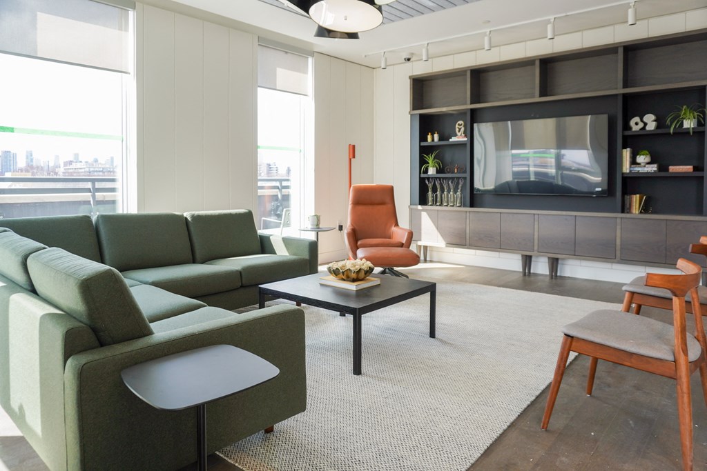 a living room with a green couch and a television