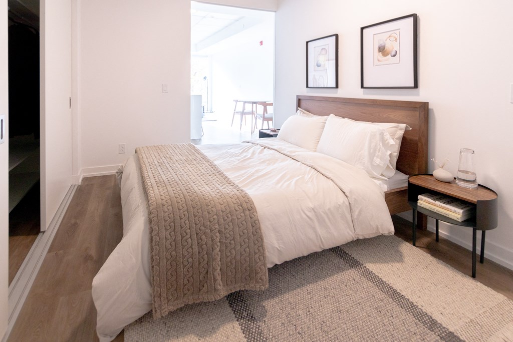 a bedroom with a bed and two pictures on the wall