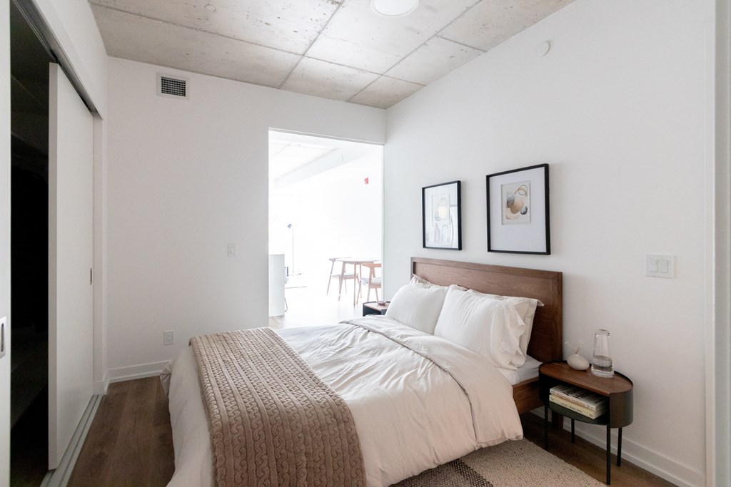 a bedroom with a bed and two pictures on the wall