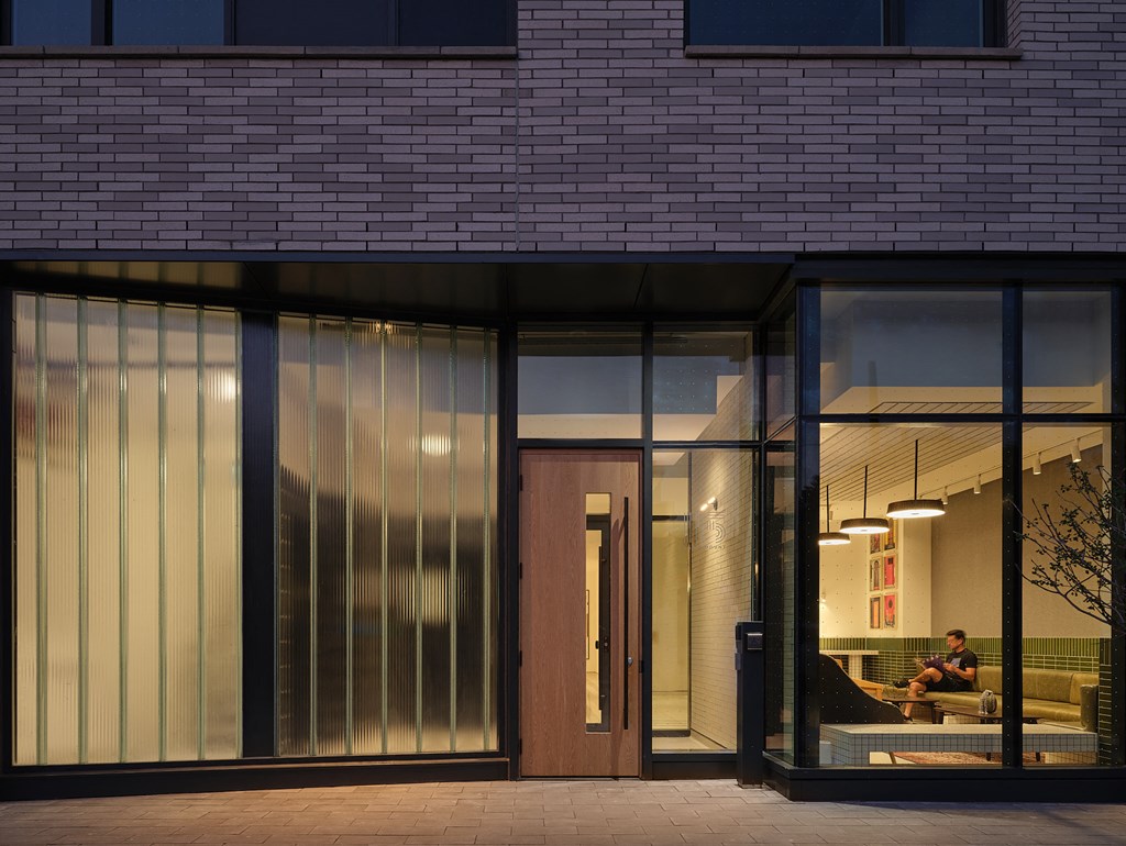 a man sitting on a couch in a lobby of a brick building