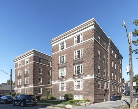 A large brick building with a parking lot in front.