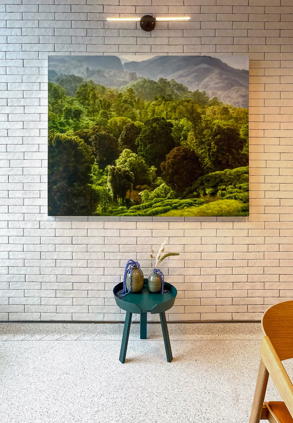 a painting of a forest on a wall above a table