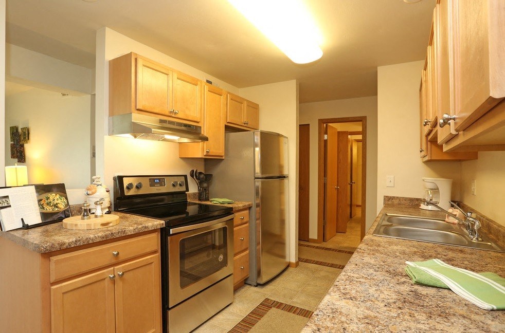 a kitchen with wooden cabinets and granite counter tops