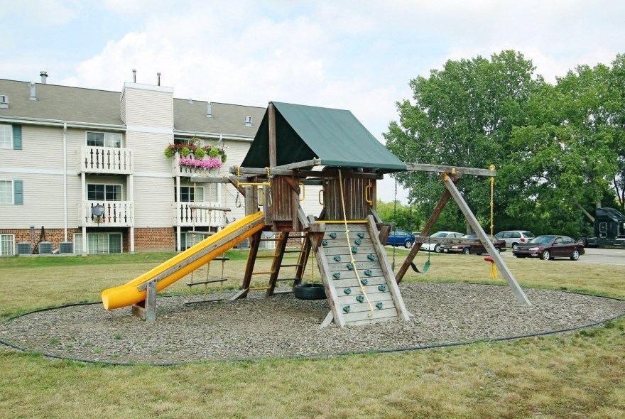 a swing set in front of an apartment building