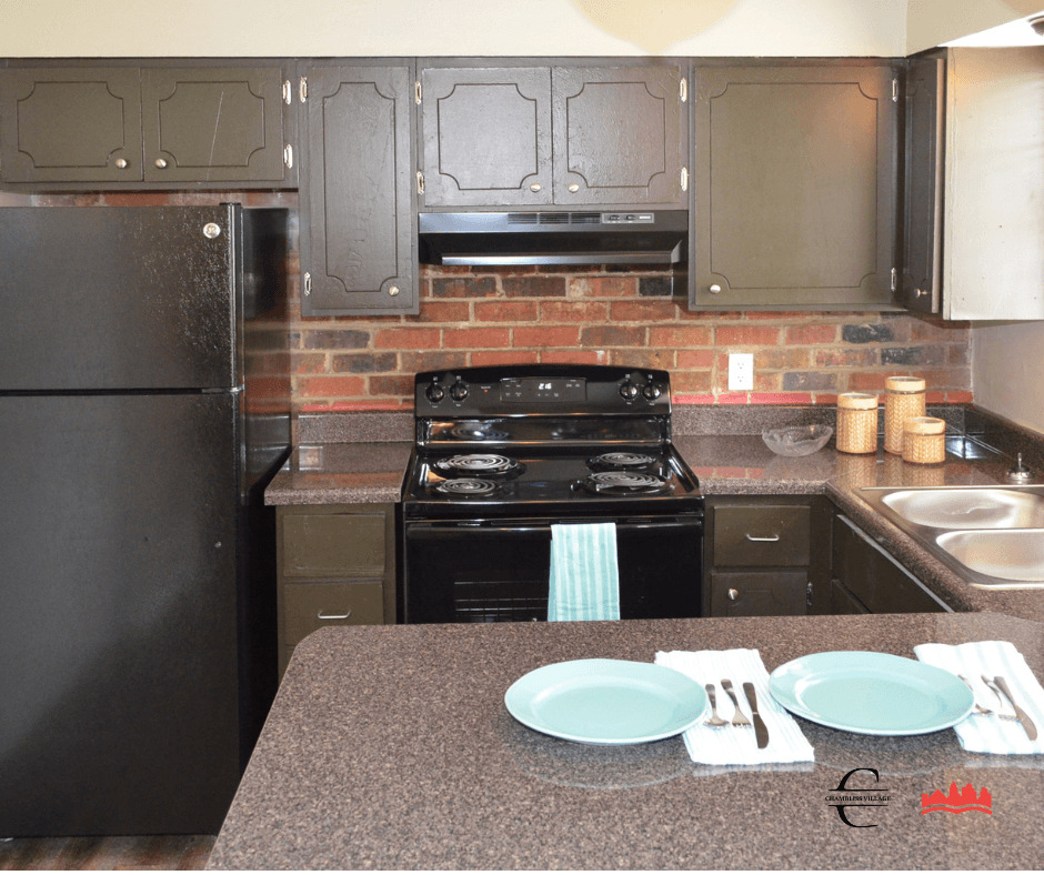 a kitchen with gray cabinets and black appliances