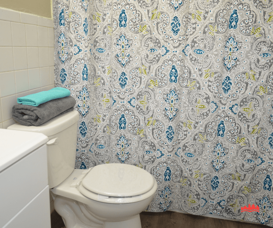 a bathroom with a toilet and a shower curtain