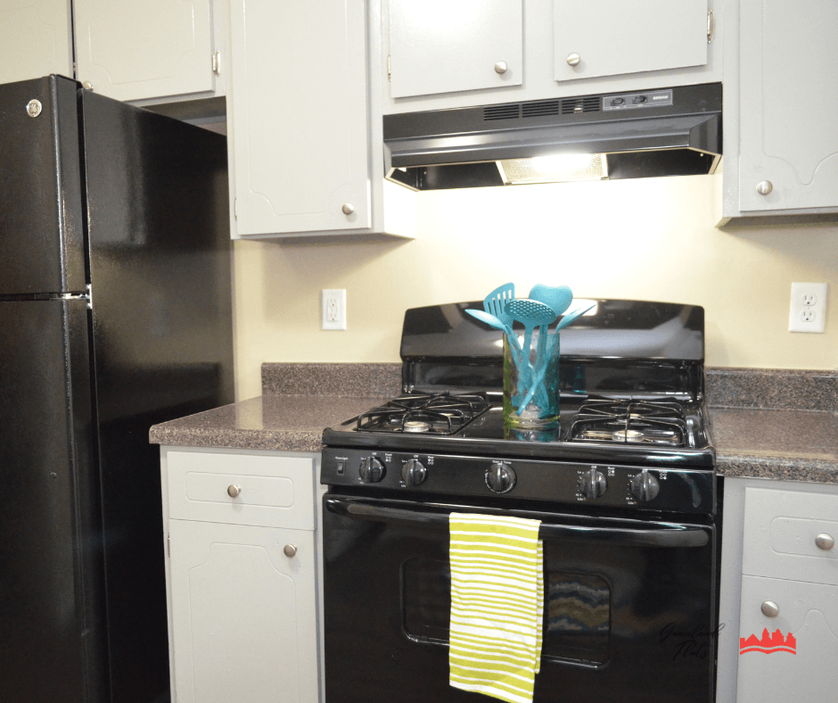 a kitchen with white cabinets and black appliances