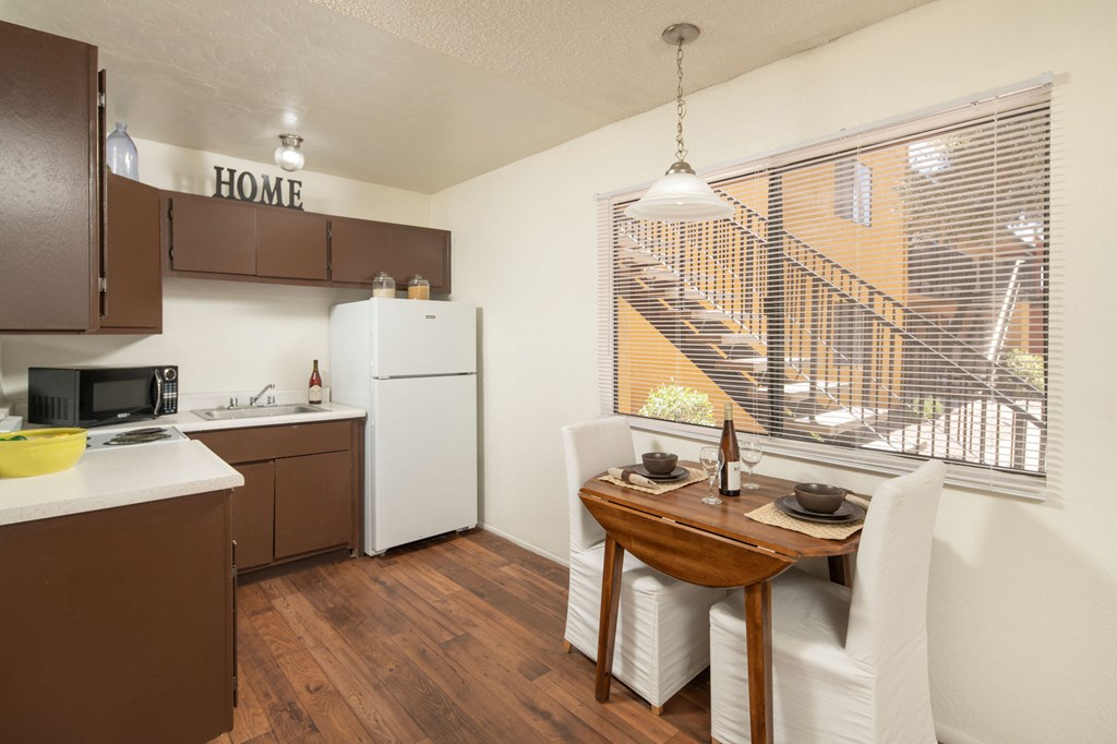 A kitchen with brown cabinets and a white refrigerator.
