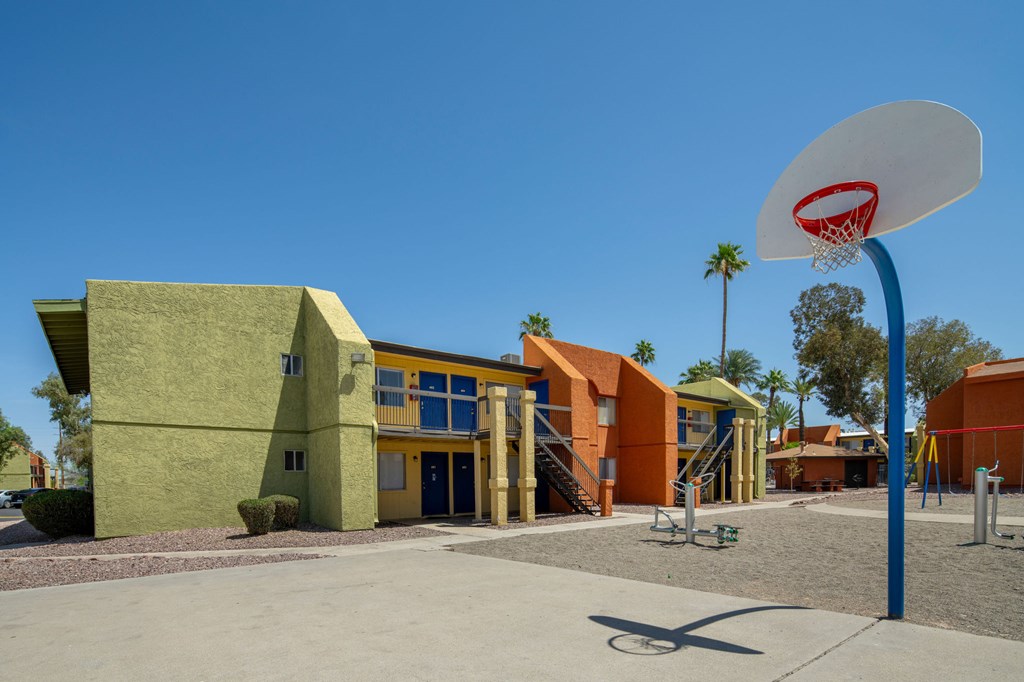 A basketball court is in front of a colorful building.