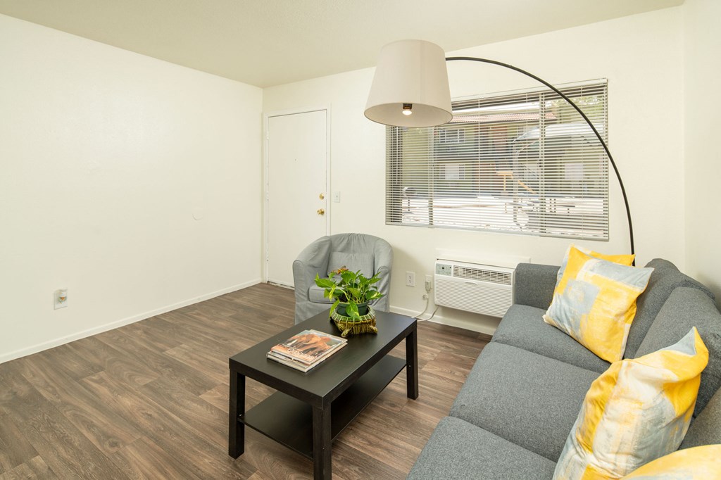 A living room with a grey couch and a black coffee table.