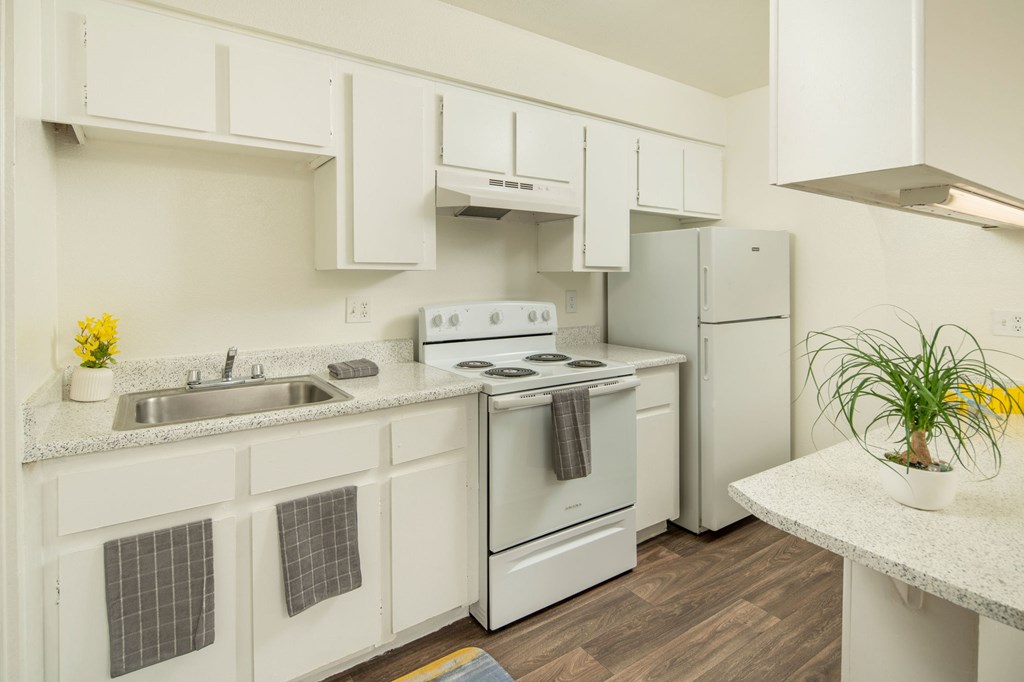 A kitchen with white cabinets and appliances.
