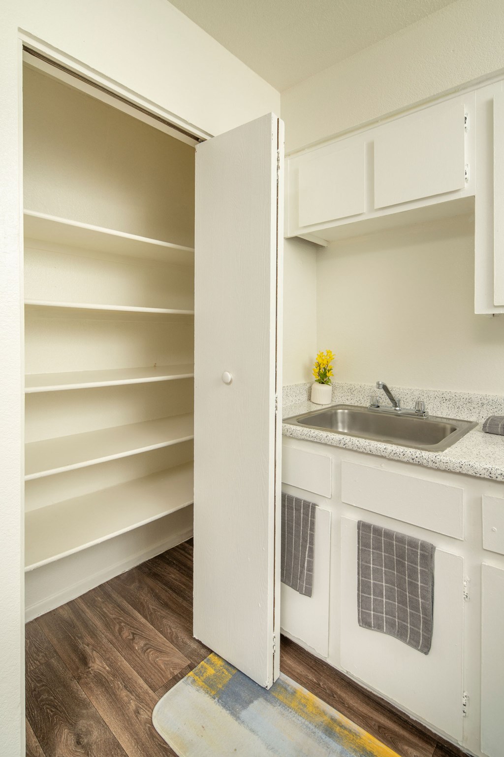 A kitchen with white cabinets and a sink.
