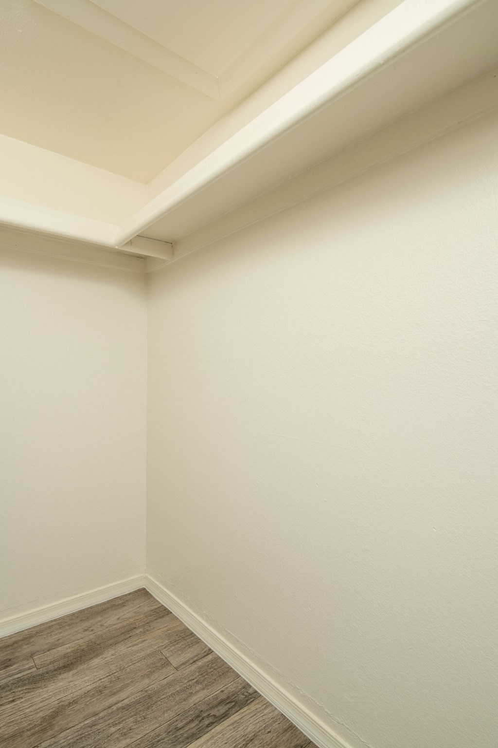 A corner of a room with a wooden floor.