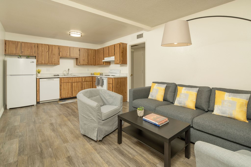 A living room with a grey couch, a grey armchair, and a coffee table.