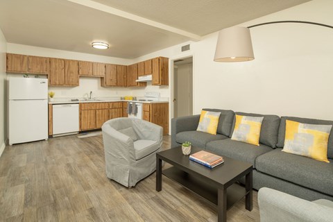 A living room with a grey couch, a grey armchair, and a coffee table.