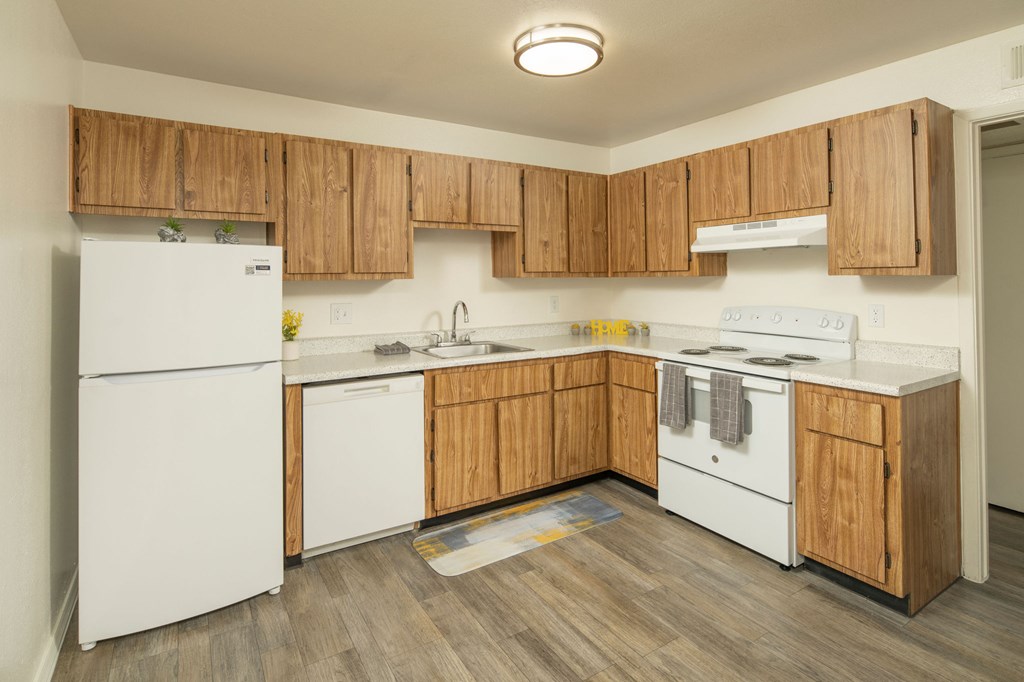 A kitchen with wooden cabinets and white appliances.