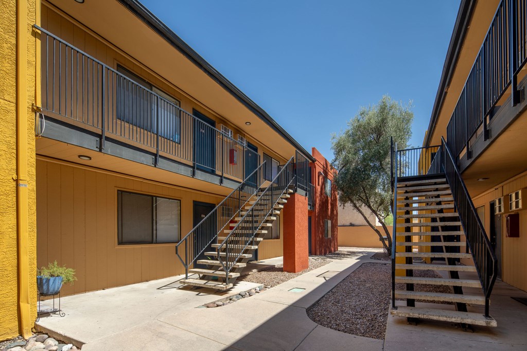 A sunny day at a modern apartment complex with staircases leading to the upper floors.