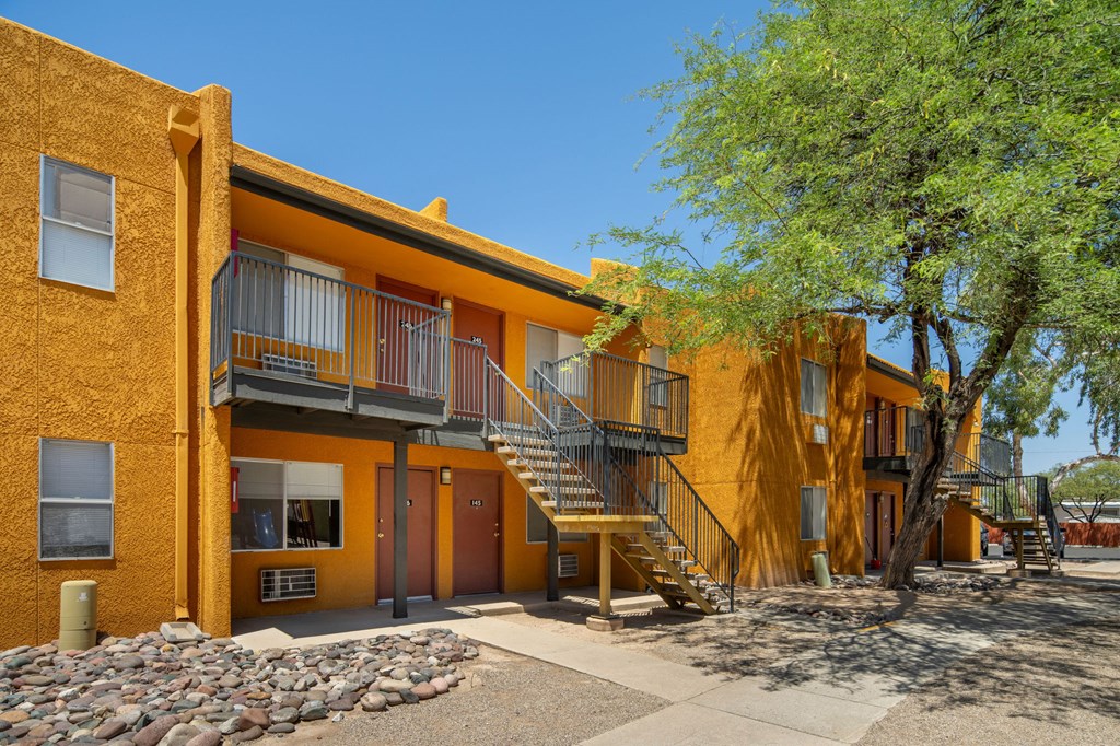 A yellow building with a tree in front of it.