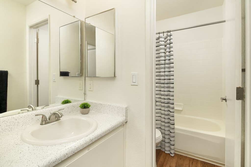 A white bathroom with a sink and a bathtub.