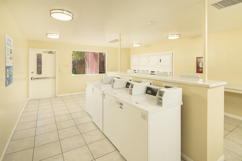 A laundromat with washers and dryers is shown.