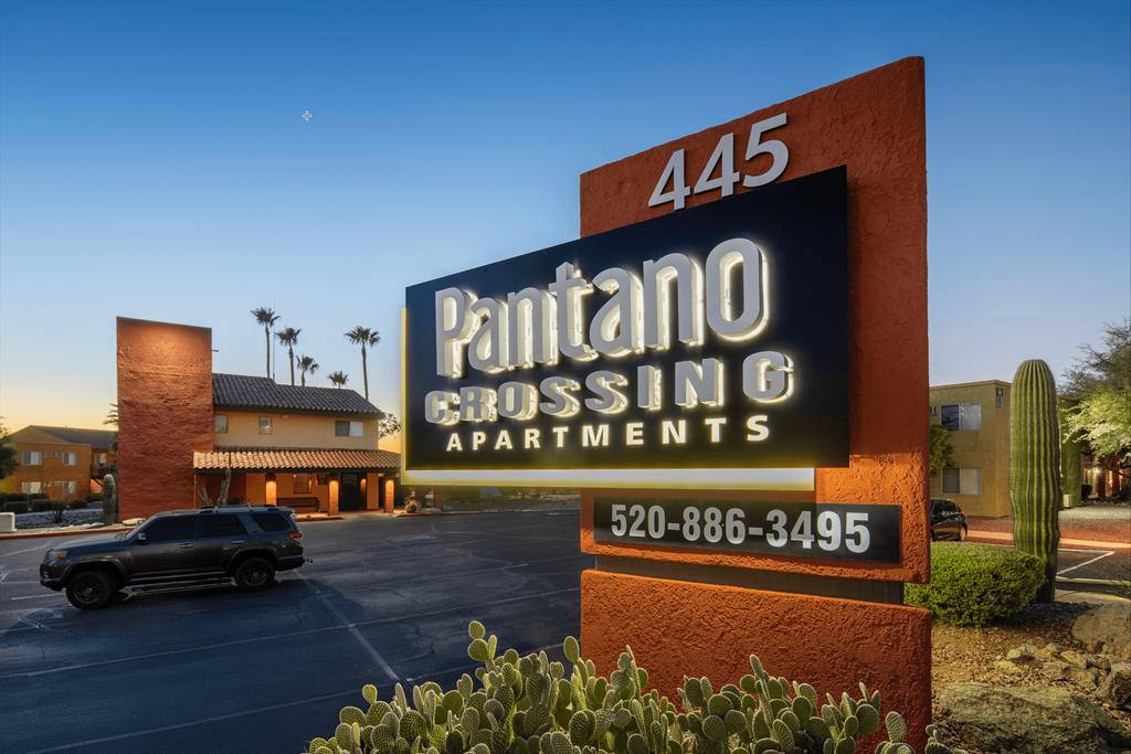 A sign for Pantano Crossing Apartments with a phone number on it.