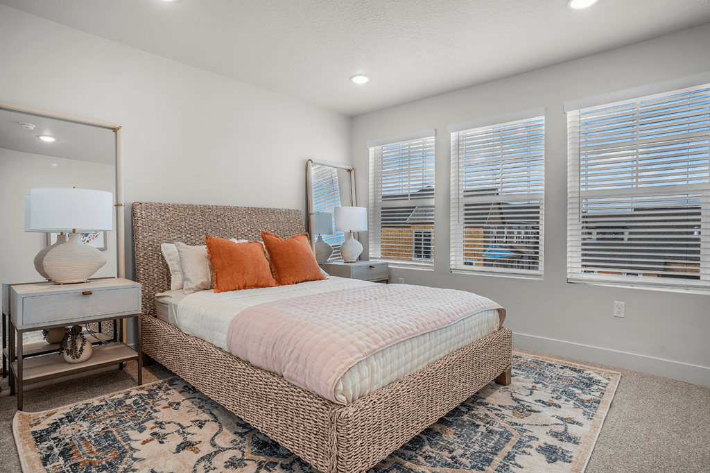 A bedroom with a large bed and a mirror on the wall.