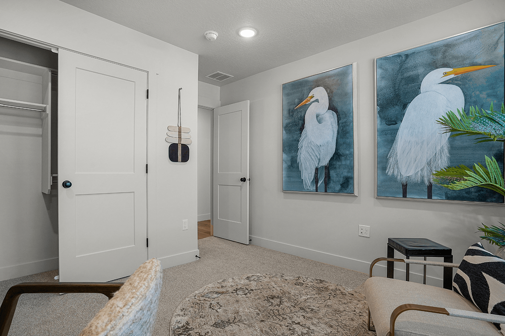 A room with a painting of a white bird on the wall.