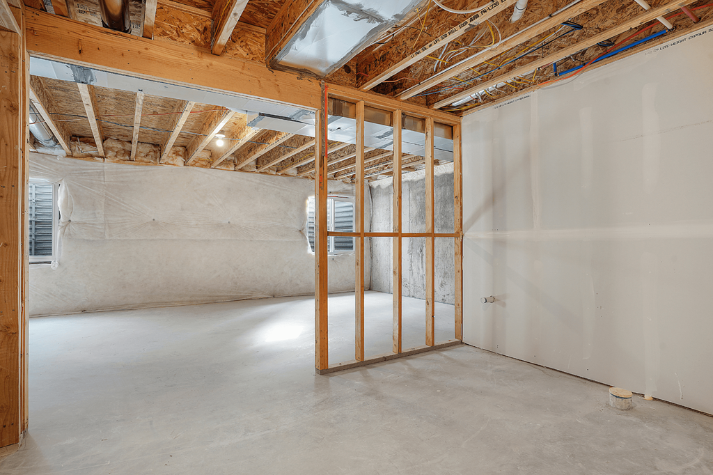 A room under construction with exposed wooden beams and unfinished walls.