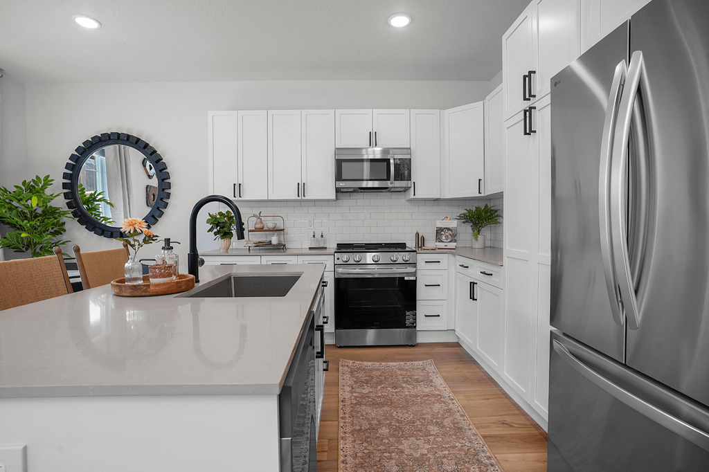 A modern kitchen with white cabinets and stainless steel appliances.