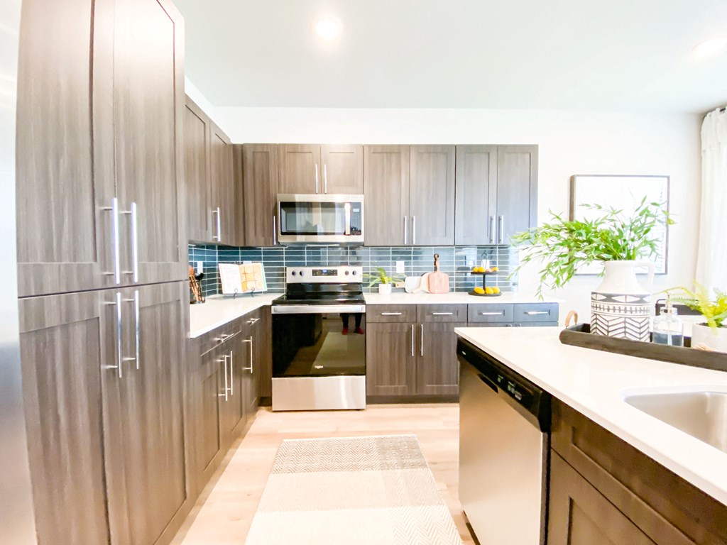 Modern dark cabinets, slate gray backsplash, white quartz counters and sleek chrome hardware
