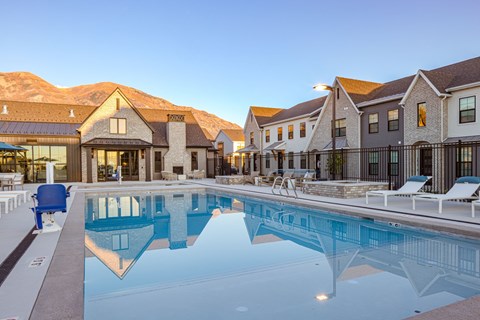 A large swimming pool in front of a resort.