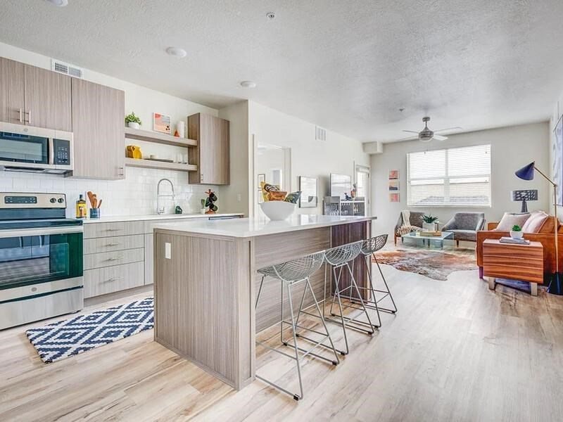 A kitchen with a bar stool and a dining table.
