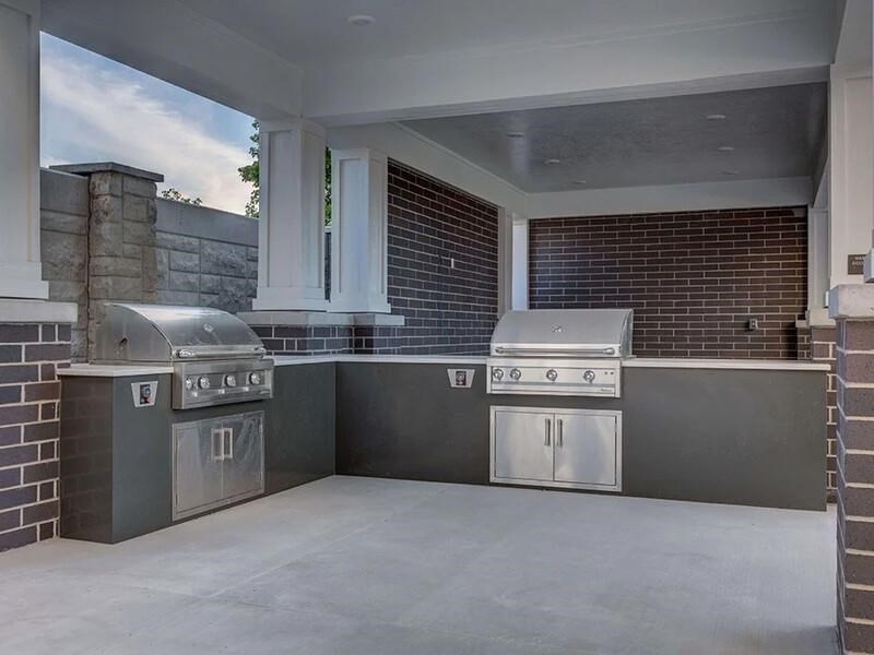A modern outdoor kitchen with a grill and sink.