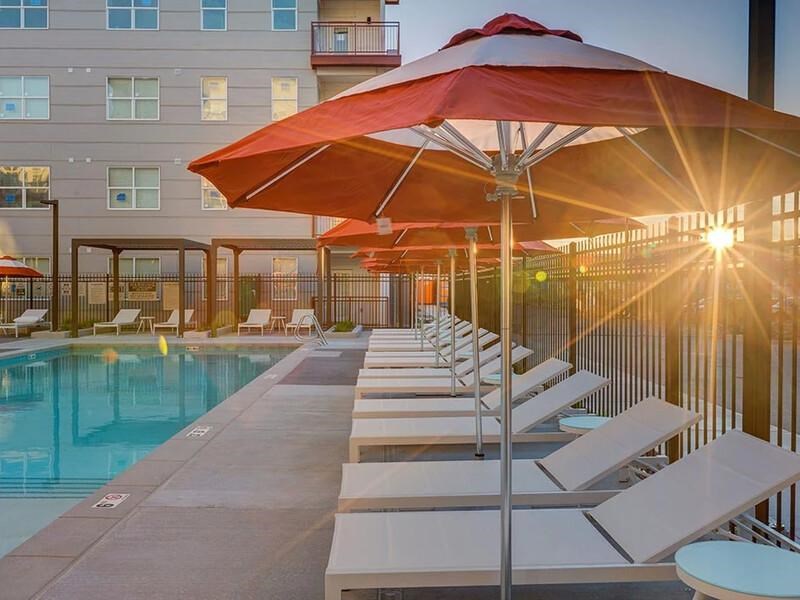 A sunny day at the pool with sunlight shining through the umbrellas.