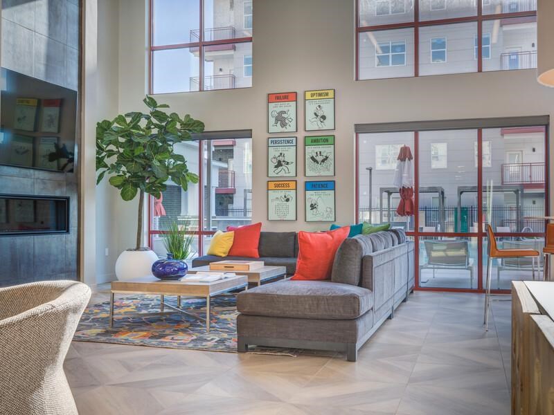 A living room with a couch, chair, and a potted plant.
