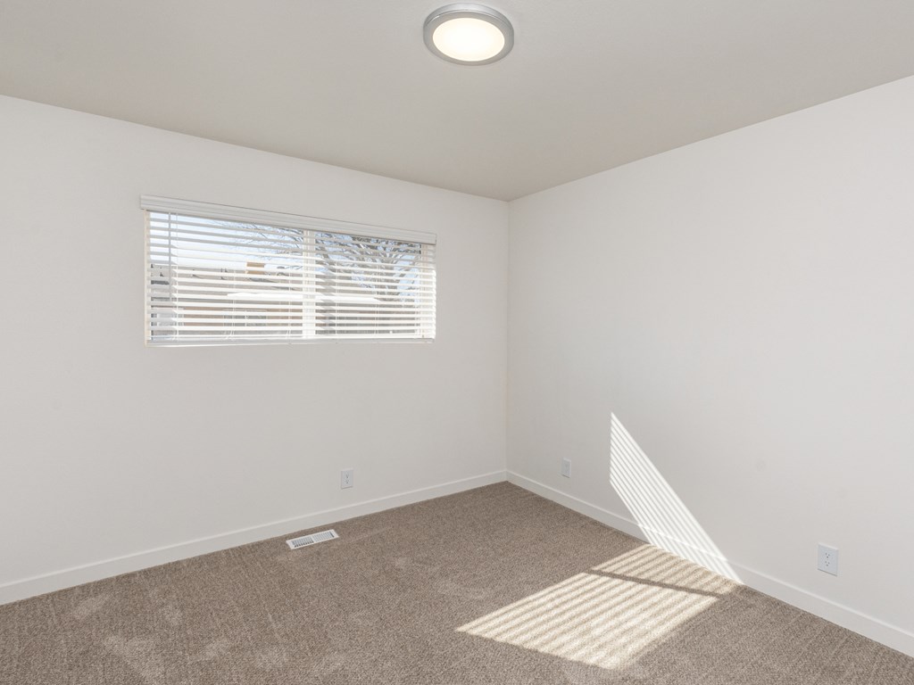 an empty room with carpet and a window