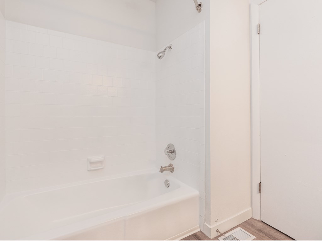 a white bathroom with a tub and a shower