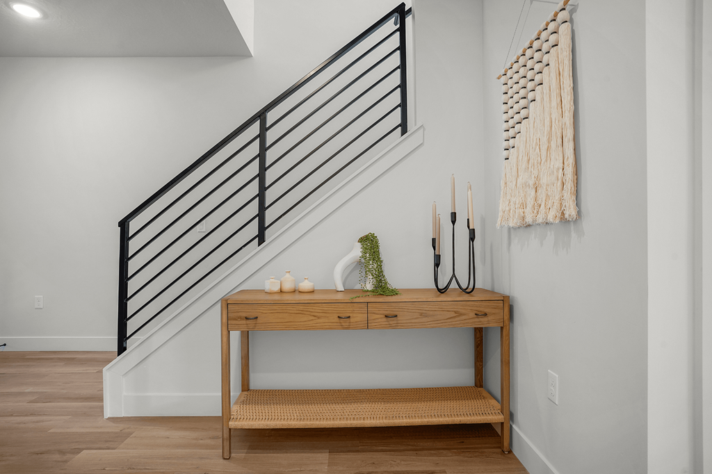 A wooden table with a candle and a plant on it.