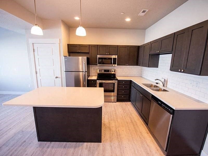 a kitchen with a white counter top and a refrigerator