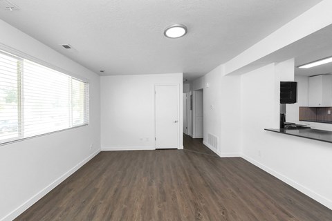 an empty living room with white walls and a window