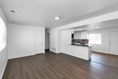 the living room and kitchen of an empty apartment